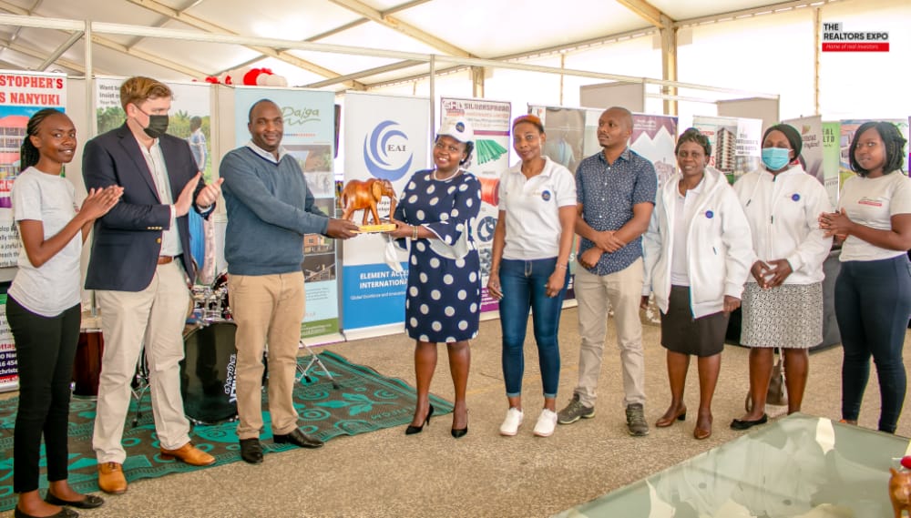 Ndegwa Gitonga the chairman of the KNCCI Laikipia Chapter flagged by Morgan of Eryrx hands over the Platinum Sponsors Award to Hannah Muriithi, EBS of HM & Co. Advocates while Kennedy of Urbanites Insurance Agency and the team looks on.