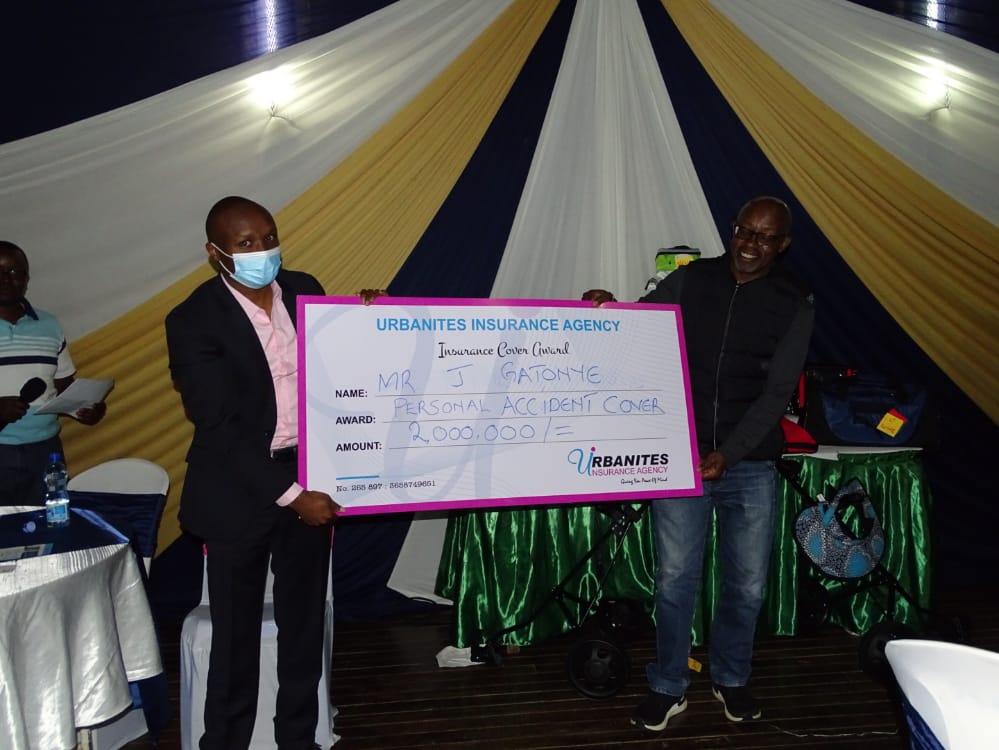 Kennedy Maina of Urbanites Insurance Agency hands over a Ksh. 2M dummy cheque to one of the winners at the Golf Tournament sponsored by the company.